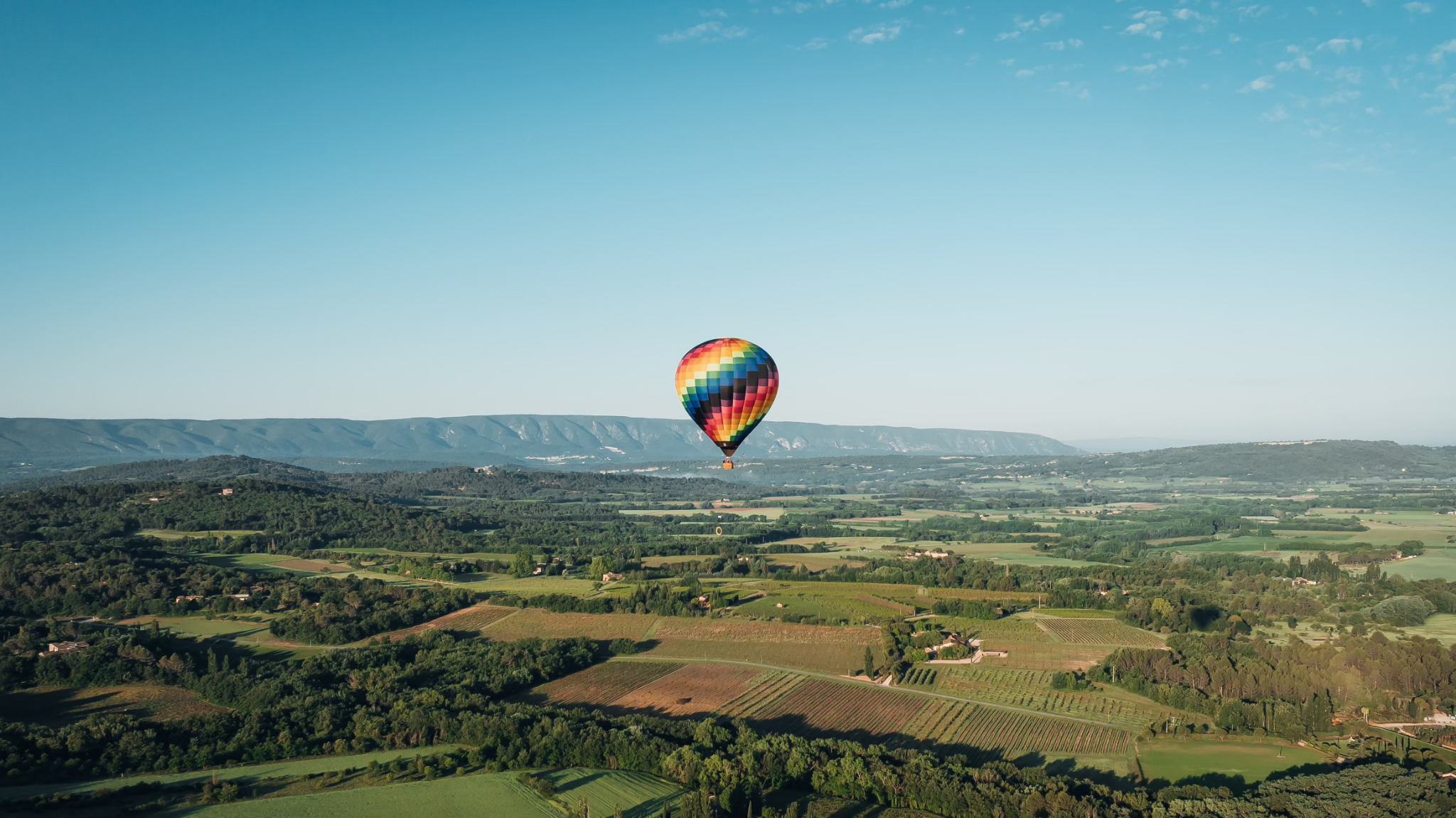 Vue aérienne depuis une montgolfière b2o sur Gap - Tallard, montrant les paysages montagneux des Hautes-Alpes.